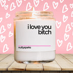a jar of i love you bitch candle on a table