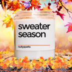 a jar of sweater season sits on a table surrounded by autumn leaves