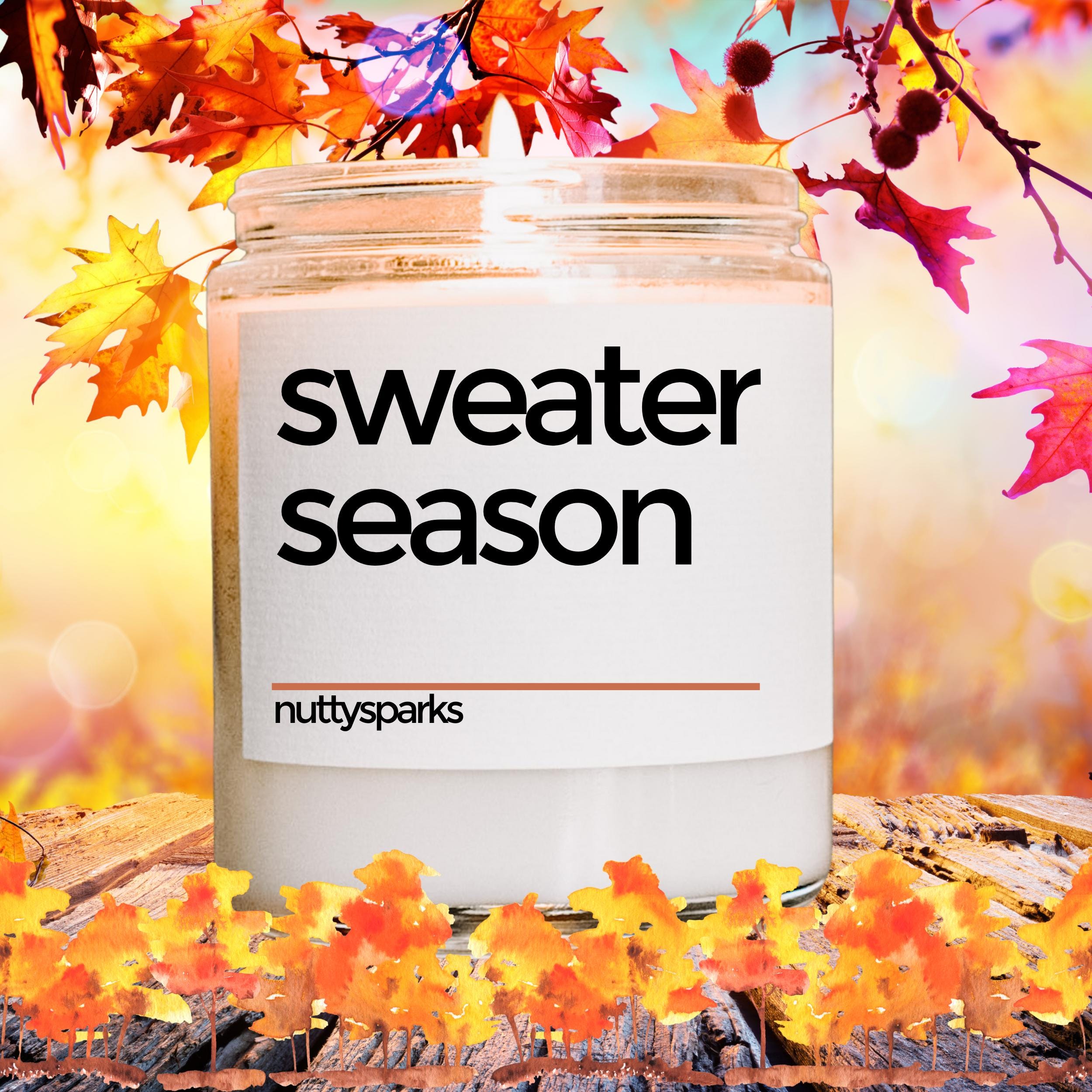 a jar of sweater season sits on a table surrounded by autumn leaves